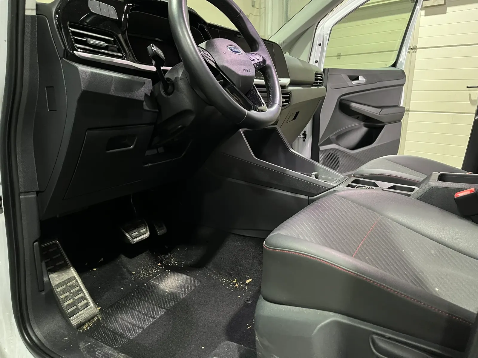 Verschmutzter Fußraum eines Ford Tourneo vor der Innenreinigung